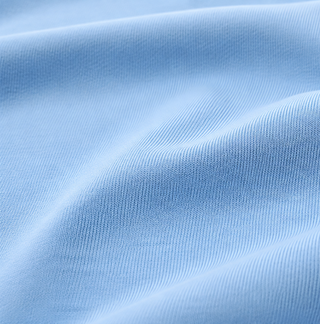 A close-up of light blue ribbed fabric with soft folds and a smooth texture.